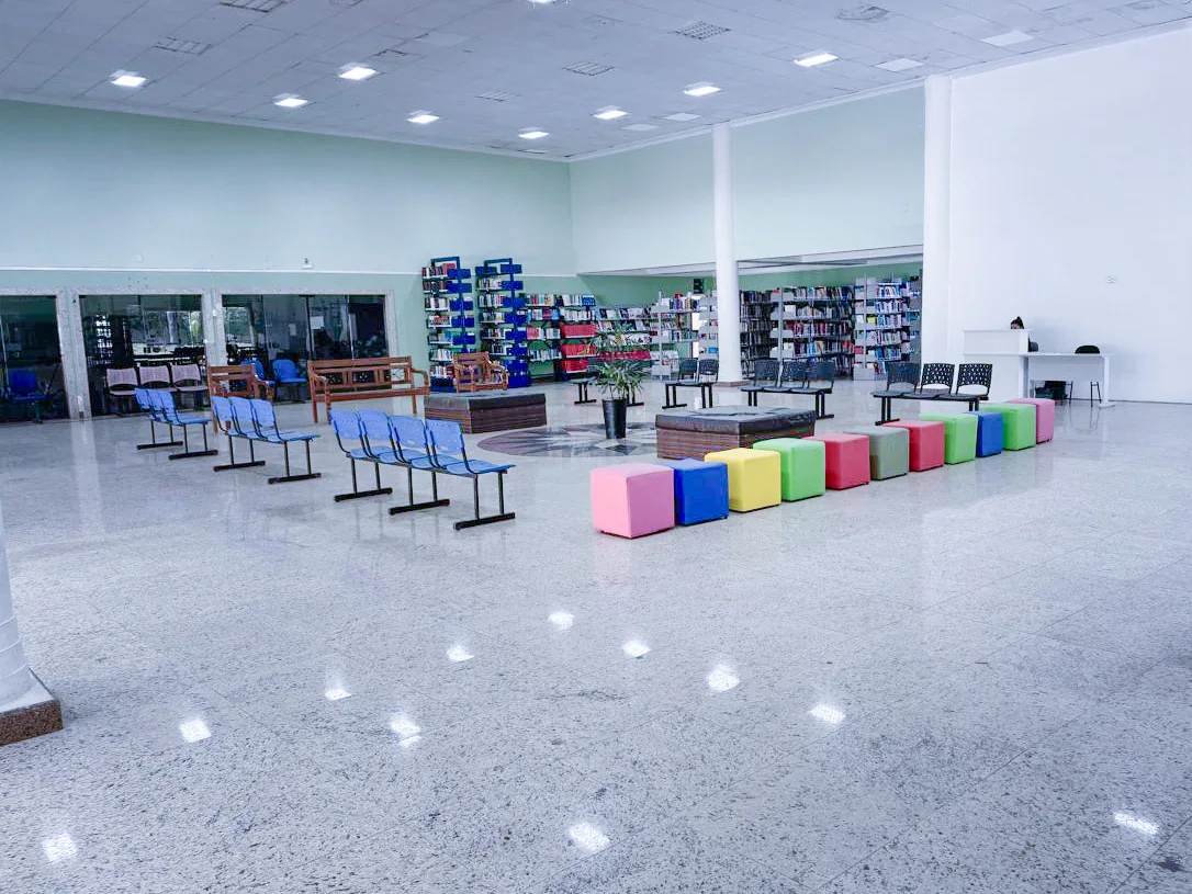 Espaço com acervo de livros e mesas de estudo na unidade do UninCor em Caxambu